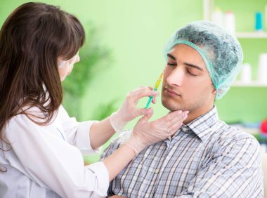 Estetik cerrah insan yüzü ameliyatına hazırlanıyor.