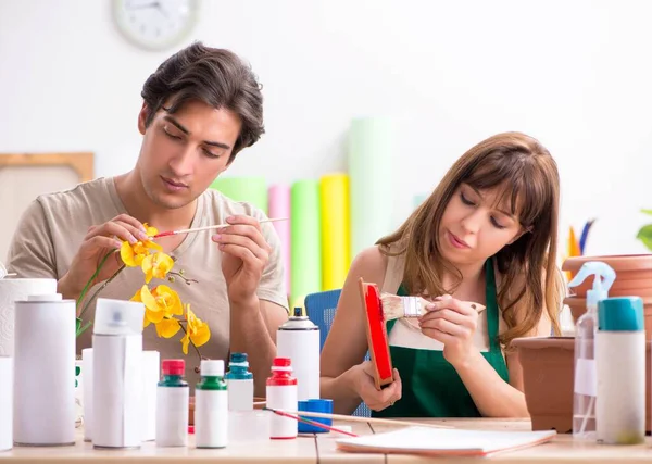 Paar dekoriert Töpfe während des Unterrichts in Werkstatt — Stockfoto