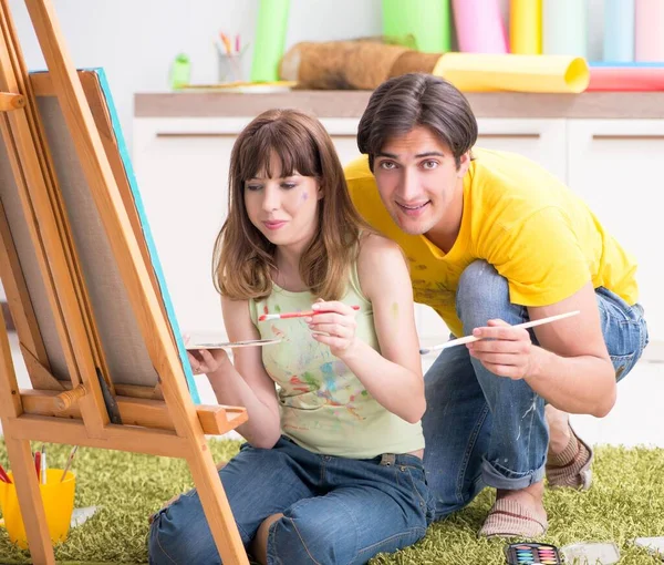 Pareja joven disfrutando de la pintura en casa — Foto de Stock
