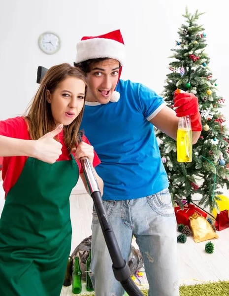 Jovem família limpeza apartamento após a festa de Natal — Fotografia de Stock