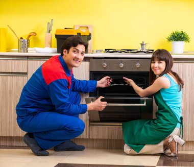 Mutfakta müteahhitle birlikte çalışan bir kadın tamir hakkında konuşuyor.