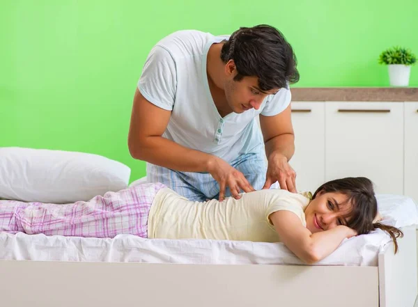 Man doet massage naar zijn vrouw in slaapkamer — Stockfoto