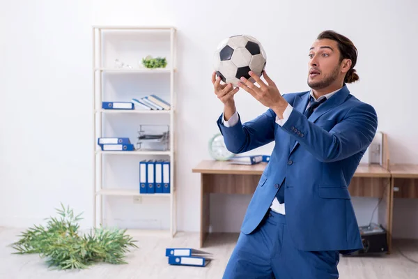 Giovane dipendente maschio che gioca a calcio in ufficio — Foto Stock