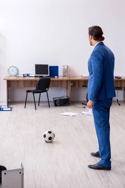 在办公室踢足球的年轻男性雇员 — 图库照片