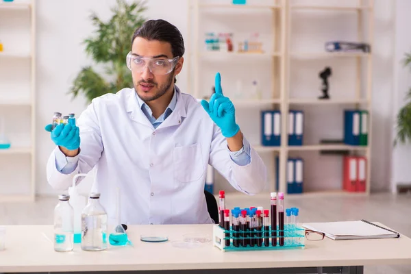 Jonge mannelijke chemicus werkzaam in het lab — Stockfoto