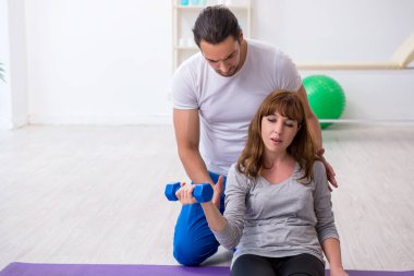 Kişisel koçla spor egzersizleri yapan genç bir kadın.