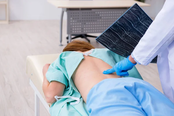 Mujer joven lesionada de espalda que visita al quiropráctico médico varón — Foto de Stock