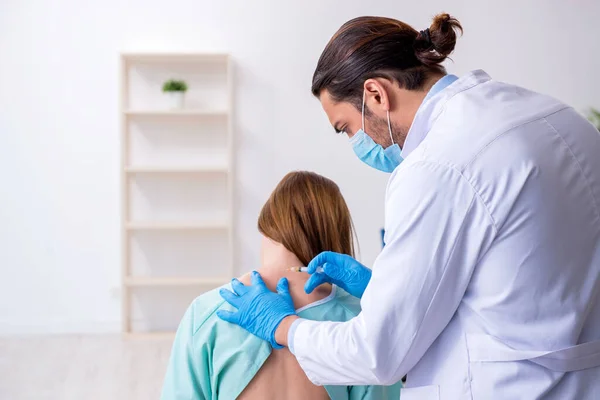 Mujer joven lesionada de espalda que visita al quiropráctico médico varón — Foto de Stock