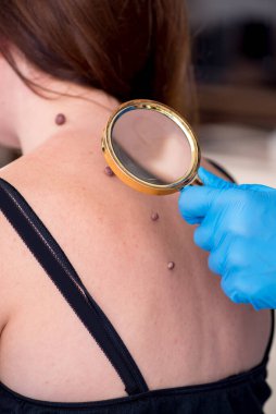 Genç bir kadın erkek doktor dermatoloğunu ziyaret ediyor.