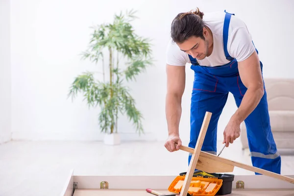 Junger männlicher Bauunternehmer installiert Möbel zu Hause — Stockfoto