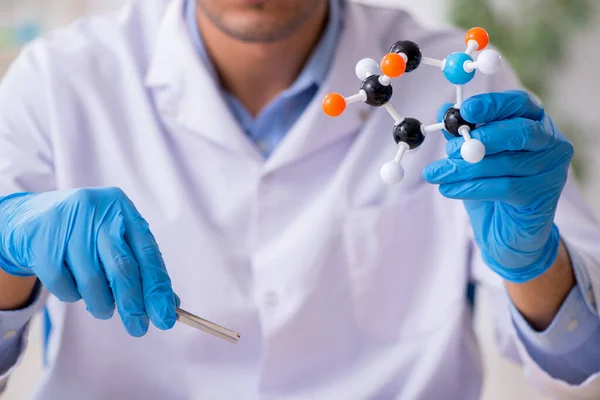 Giovane assistente di laboratorio maschile nel concetto di sintesi dei farmaci — Foto Stock