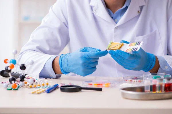 Young male lab assistant in drug synthesis concept — Stock Photo, Image