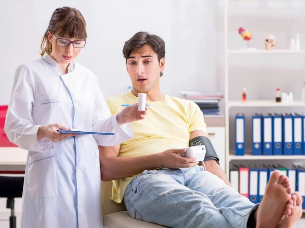 Young doctor checking patients blood pressure — Stock Photo, Image