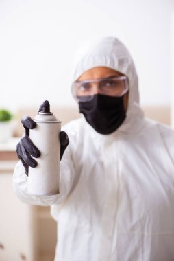 Genç erkek müteahhit evde haşere kontrolü yapıyor.