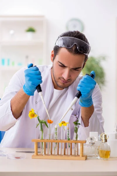 Mladý muž chemik v konceptu syntézy parfémů — Stock fotografie
