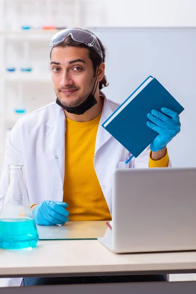 Young male chemist student preparing for exam