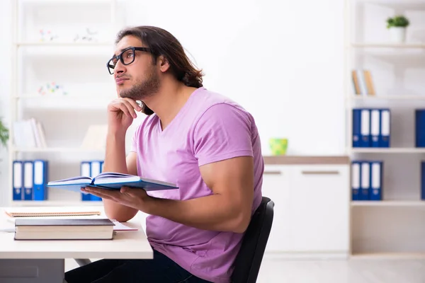 Ung manlig student förbereder sig för tentor i klassrummet — Stockfoto