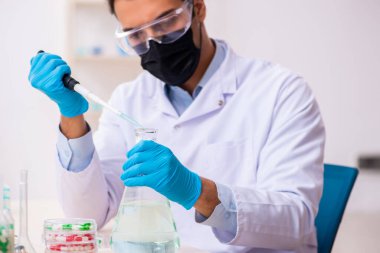 Genç erkek kimyager uyuşturucu sentezi konseptinde