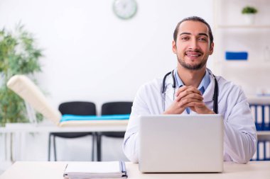 Klinikte çalışan yakışıklı genç erkek doktor.