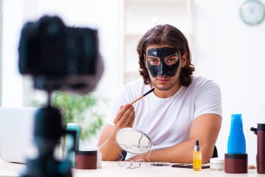 Genç erkek kozmetikçi blogu için video kaydediyor.