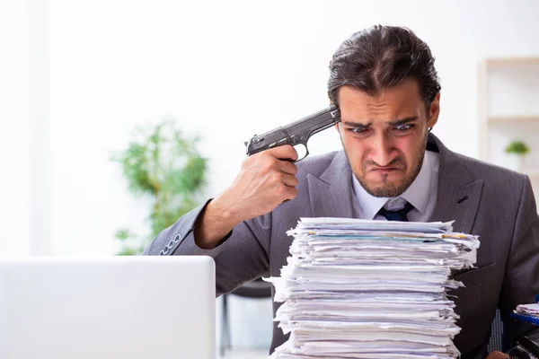 Jovem funcionário do sexo masculino infeliz com trabalho excessivo — Fotografia de Stock