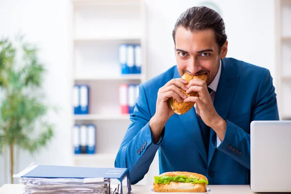 Giovane dipendente maschio che fa colazione sul posto di lavoro — Foto Stock