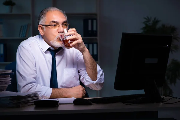 Viejo empleado trabajando hasta tarde en la oficina — Foto de Stock