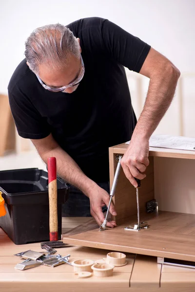 Viejo carpintero trabajando en interiores — Foto de Stock