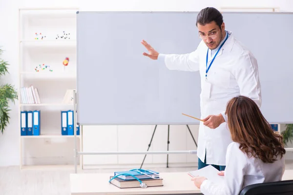 Fiatal férfi tanár orvos és női diák az osztályteremben — Stock Fotó