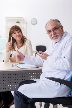 Hamile kadın deneyimli bir jinekoloğu ziyaret ediyor.