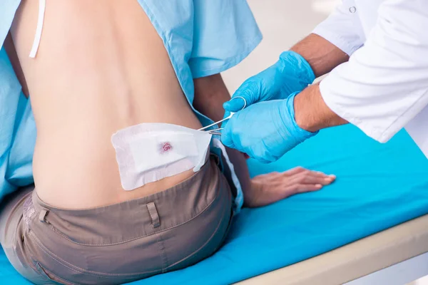 Injured young woman visiting young male doctor — Stock Photo, Image