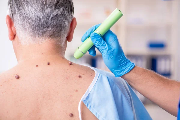 Old man visiting young male doctor dermatologist — Stock Photo, Image