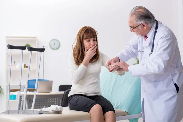 Jovem mulher ferida visitando médico traumatologista experiente — Fotografia de Stock