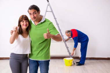 Genç çift ve ev yenileme konseptinde yaşlı müteahhit.