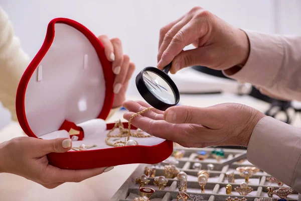 Jonge vrouw op bezoek bij oude mannelijke juwelier — Stockfoto