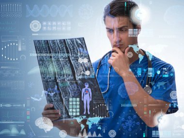 Genç doktor sağlık konseptinde x-ray görüntüsüne bakıyor