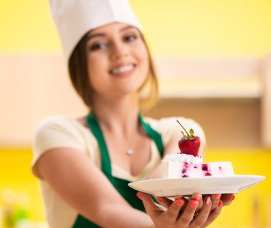 Genç aşçı mutfakta kek pişiriyor.