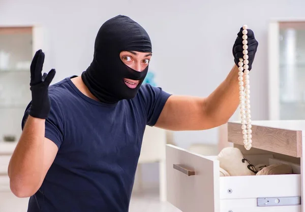 Ladrão usando balaclava roubando coisas valiosas — Fotografia de Stock