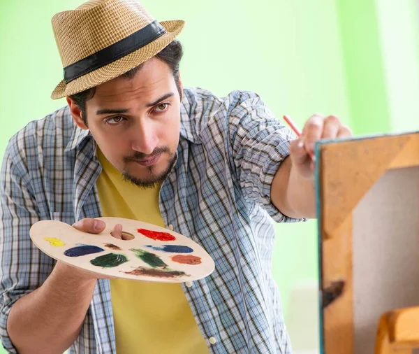 Joven artista masculino trabajando en una nueva pintura en su estudio — Foto de Stock