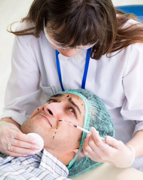 A plasztikai sebész felkészül a férfi arcon végzett műtétre — Stock Fotó