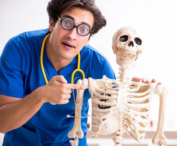 Grappige dokter met skelet in ziekenhuis — Stockfoto