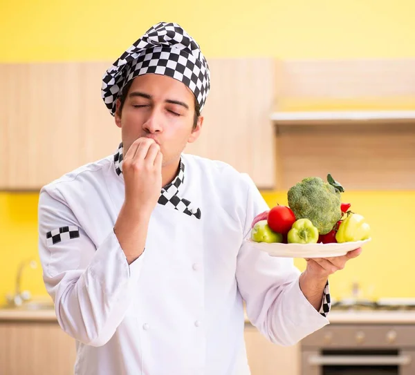 Młody profesjonalny kucharz przygotowuje sałatkę w domu — Zdjęcie stockowe