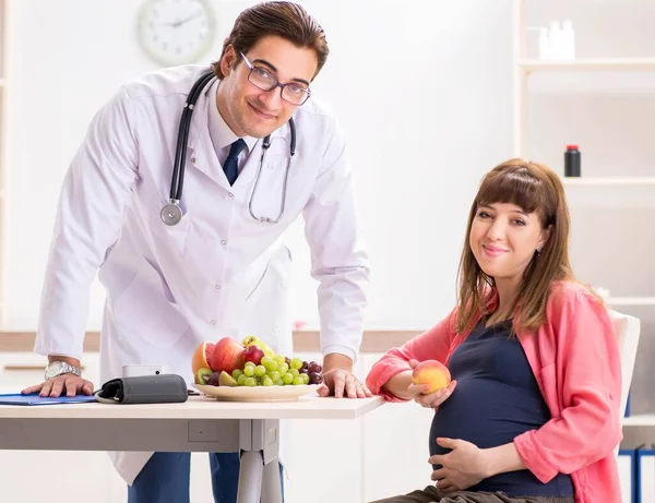 Mujer embarazada visitando al médico discutiendo dieta saludable — Foto de Stock