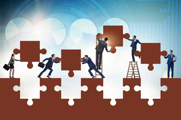 Businessman in teamwork concept with jigsaw puzzle