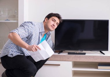 Bozuk televizyonu tamir etmeye çalışan adam