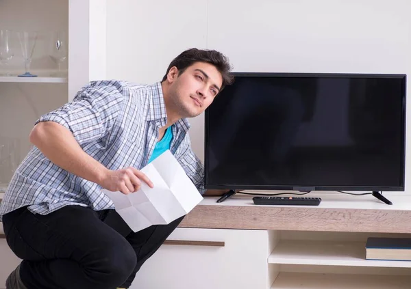 Hombre tratando de arreglar la televisión rota — Foto de Stock