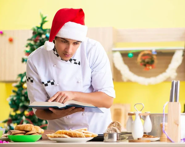 Young chef husband working in kitchen at Christmas eve — Stock Photo, Image