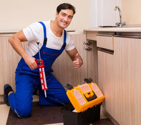 Jonge reparateur werkt in de keuken — Stockfoto