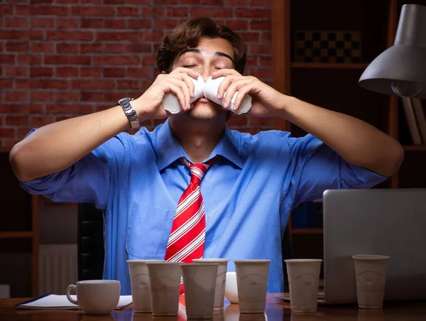 Young employee drinking coffee working at night shift — Stock Photo, Image