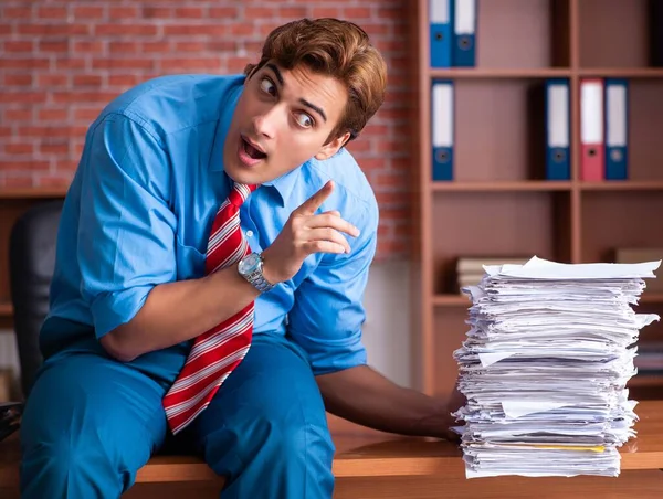 Junge Angestellte mit exzessiver Arbeit im Büro — Stockfoto